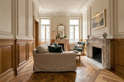 Salon ancien rénové avec boiseries en chêne massif sur mesure et parquet en point de Hongrie, alliant charme haussmannien et menuiserie artisanale contemporaine.